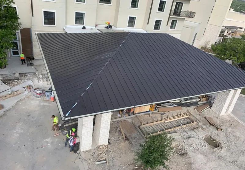 Metal roofing installation team working on a commercial building in Epsom